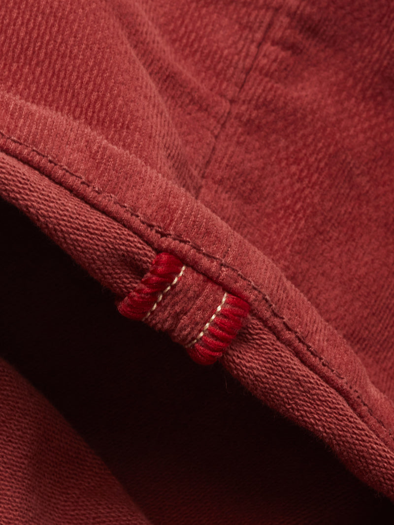 Close-up of soft dobby corduroy on Blue de Gênes BGpaulo Ottawa Trousers - Henna, featuring visible stitching and a small loop in thick red thread with white accents—reflecting the refined craftsmanship of the Ottawa line.