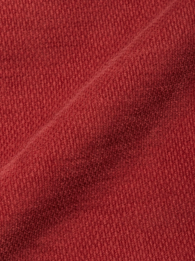 Close-up of the BGpaulo Ottawa Trousers - Henna by Blue de Gênes, featuring textured reddish-brown dobby corduroy fabric with a diagonal fold, highlighting its woven pattern and subtly soft surface.