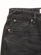 Close-up of the upper part of Blue de Gênes Giacomo BLK Used Jeans in grey denim, made in Italy, featuring a relaxed loose fit, waistband, belt loop, front pocket, and a small badge with a red and white cross near the pocket.