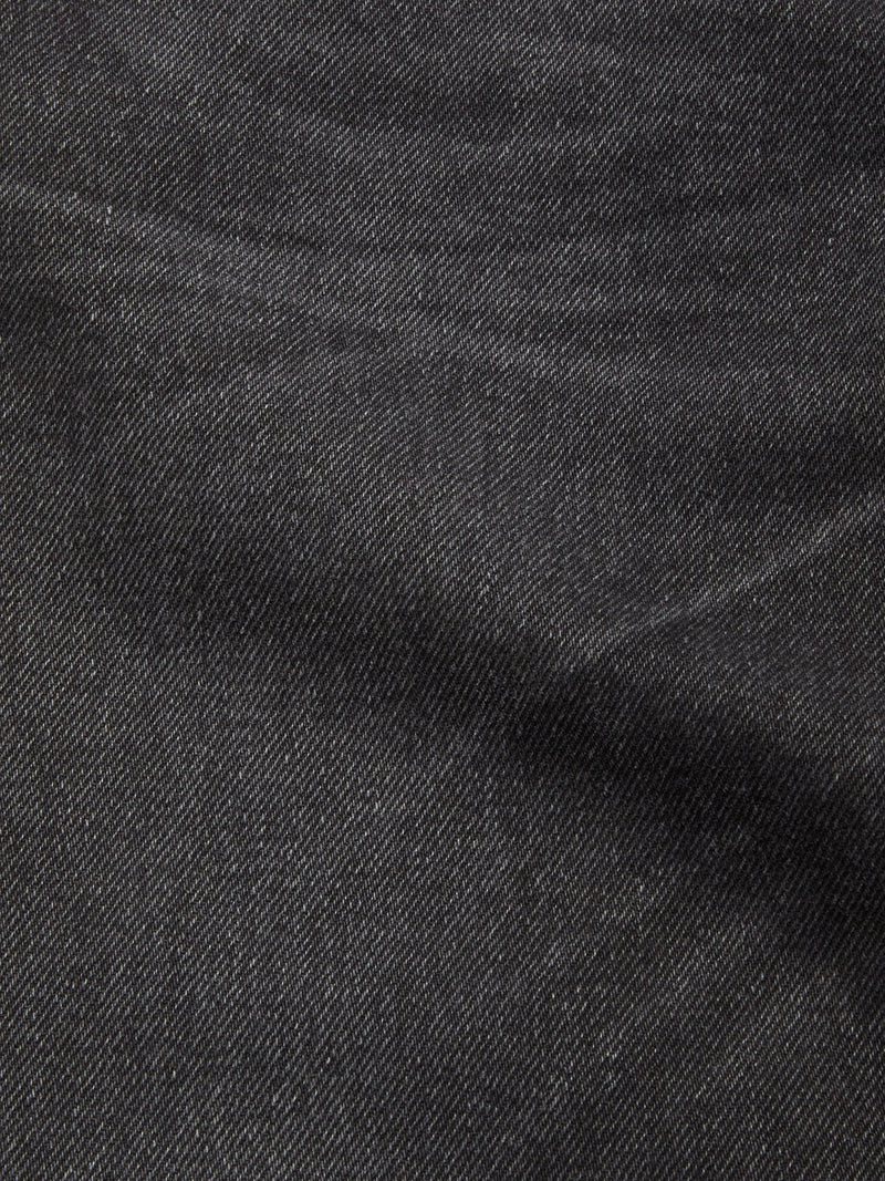 Close-up of the textured black-grey denim fabric on Blue de Gênes Giacomo BLK Used Jeans, highlighting the subtle diagonal weave and gentle creases characteristic of this relaxed, Italian-made style.