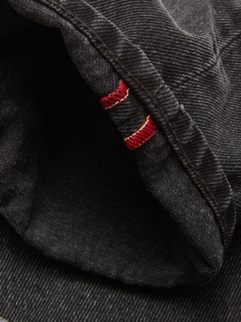 Close-up of the cuff on Blue de Gênes Giacomo BLK Used Jeans in grey denim, featuring a folded hem with red and white selvedge stitching detail.