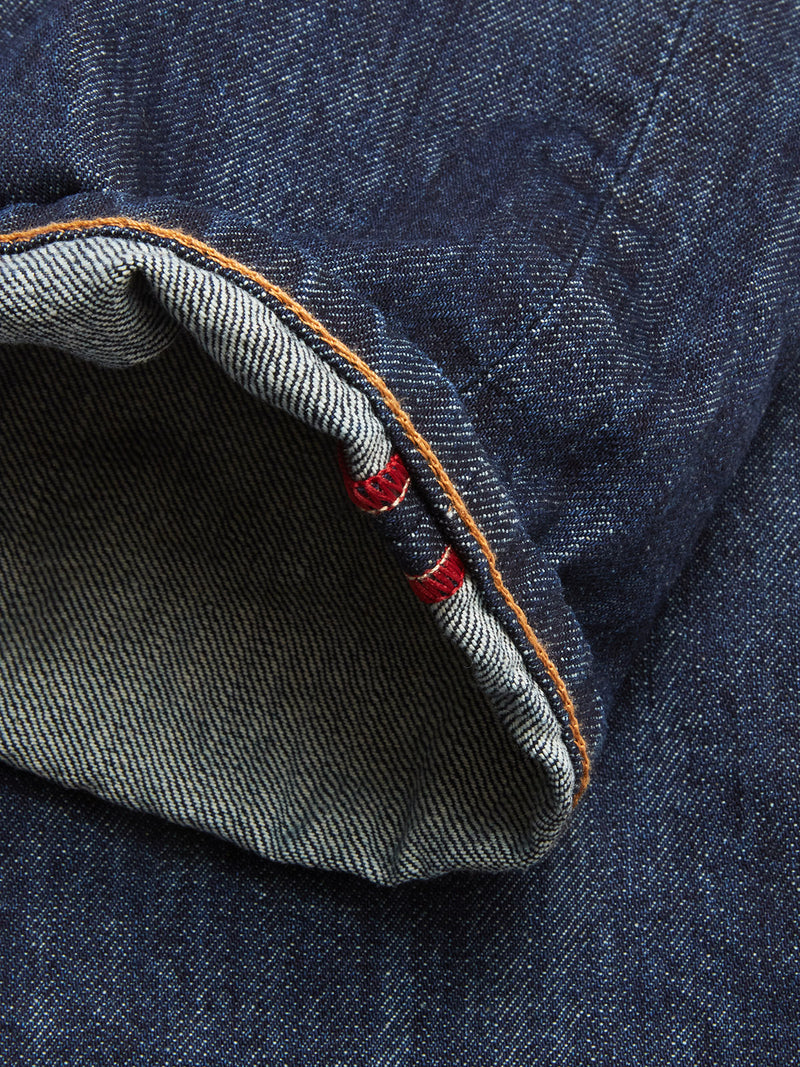 A close-up of the cuff on Blue de Gênes Giacomo Dark Horse Jeans in Denim Blue showcases the inside seam with distinctive white and red selvedge edge and contrasting orange stitching.