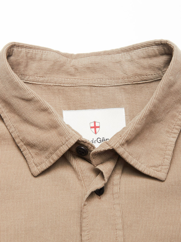 Close-up of the Zamboni Velu Shirt - Fungi by Blue de Gênes, showing its tan baby corduroy collar, partially unbuttoned, and a white neck label with the brand’s red shield logo and black text.