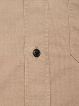 Close-up of the Blue de Gênes Zamboni Velu Shirt - Fungi, featuring garment-dyed baby corduroy with fine vertical ridges, a black button, and a partial view of the right chest pocket.