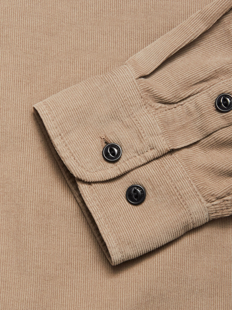 A close-up of the Zamboni Velu Shirt - Fungi by Blue de Gênes, showing its beige baby corduroy sleeve with visible textured ridges and a cuff secured by two black buttons.