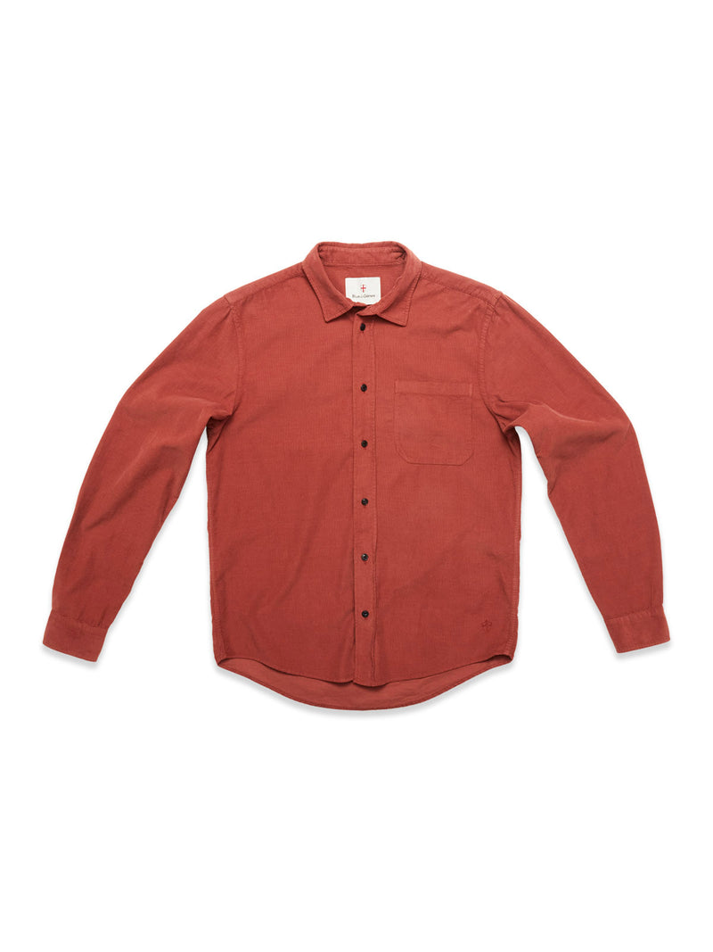 The Blue de Gênes Zamboni Velu Shirt in Henna is a long-sleeve, button-up shirt with a single chest pocket, shown garment dyed in muted red and laid flat on a white background.