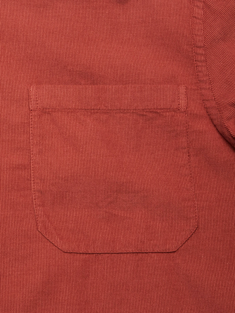 Close-up of the Zamboni Velu Shirt in Henna by Blue de Gênes—a garment-dyed baby corduroy shirt with fine vertical ridges, a front patch pocket, and detailed stitching.