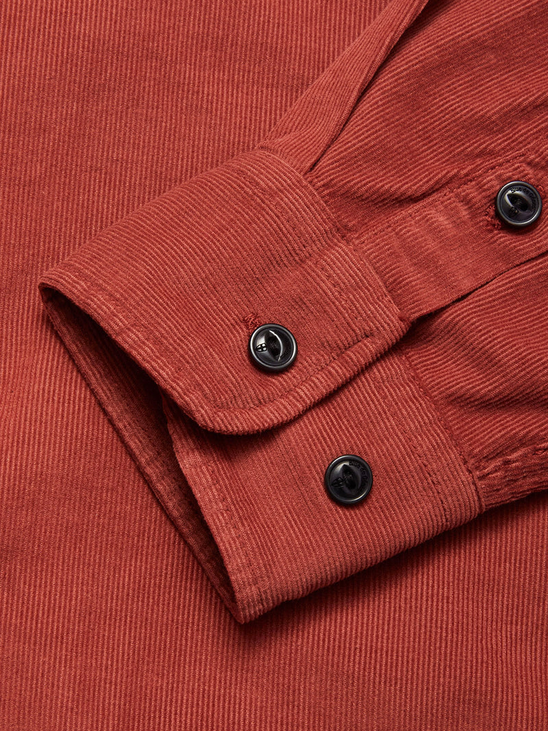 Close-up of the Zamboni Velu Shirt - Henna by Blue de Gênes, showing the red corduroy sleeve with two black cuff buttons and garment-dyed ribbed texture.
