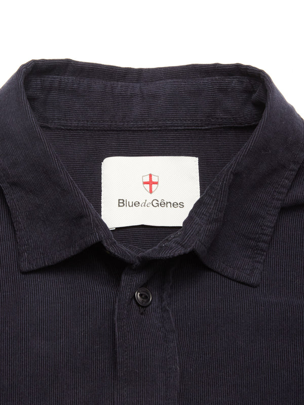 A close-up of the Zamboni Velu Shirt in navy baby corduroy, featuring a Blue de Gênes label inside the collar beneath a red and white shield emblem.