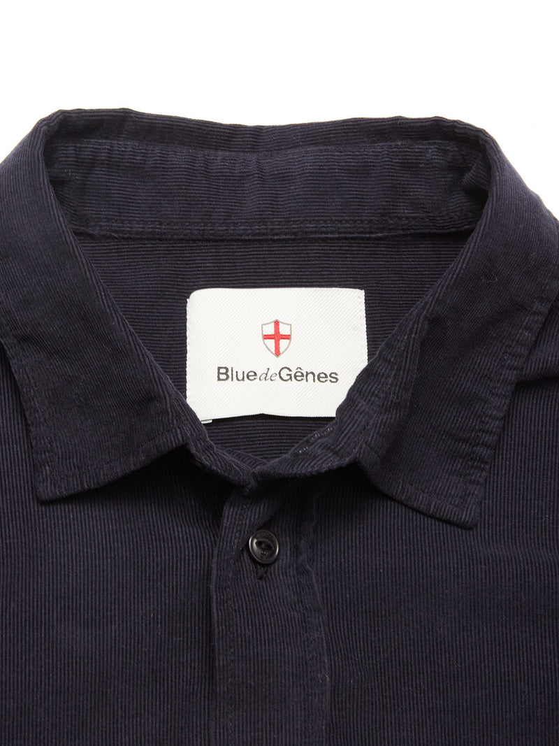 A close-up of the Zamboni Velu Shirt in navy baby corduroy, featuring a Blue de Gênes label inside the collar beneath a red and white shield emblem.