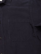 Close-up of the Blue de Gênes Zamboni Velu Shirt in Navy, a garment-dyed baby corduroy shirt with a soft ribbed texture, left chest pocket, and black buttons along the front placket.