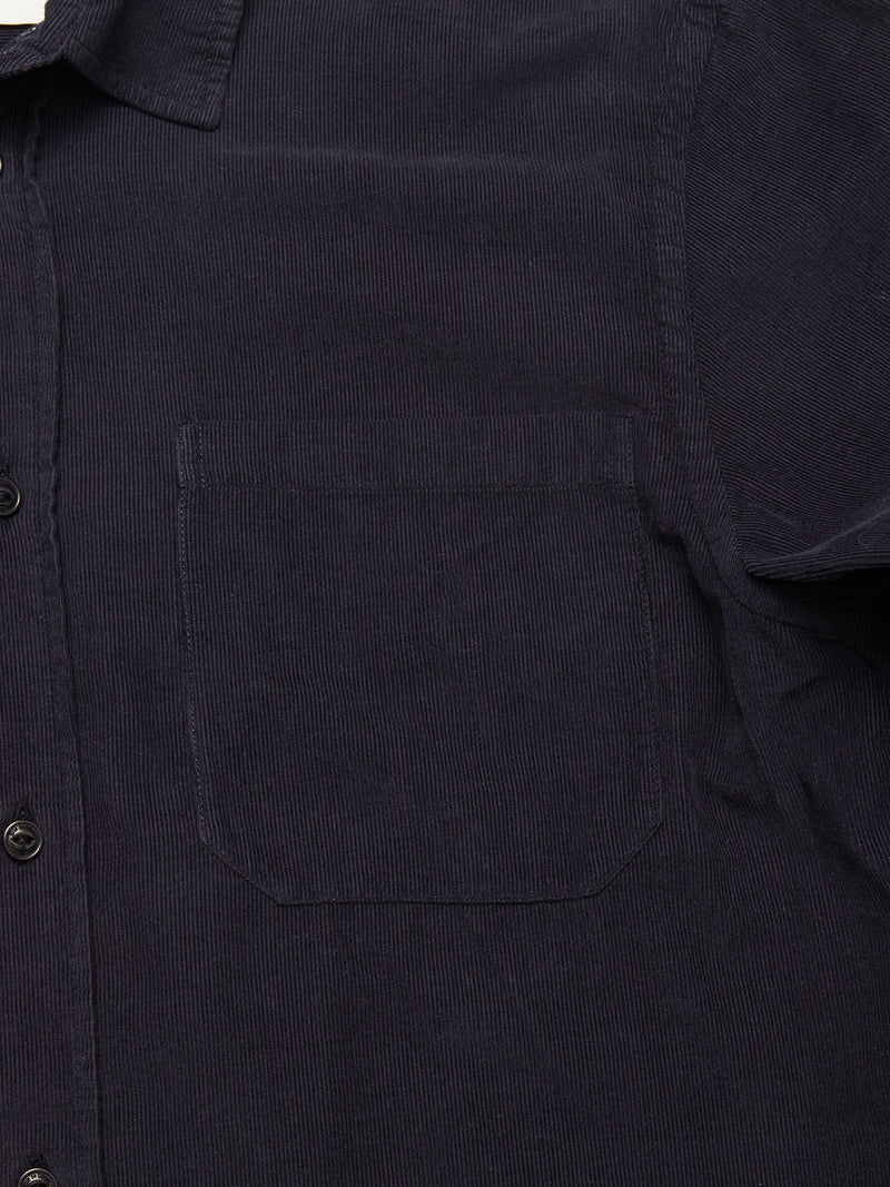 Close-up of the Blue de Gênes Zamboni Velu Shirt in Navy, a garment-dyed baby corduroy shirt with a soft ribbed texture, left chest pocket, and black buttons along the front placket.