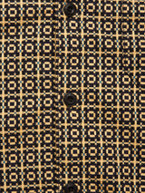 Close-up of the Manga Overshirt – Black Pattern by Blue de Gênes. Made from cotton, it features black buttons and a striking geometric design in yellow, blue, and black—an elevated men’s workwear piece.