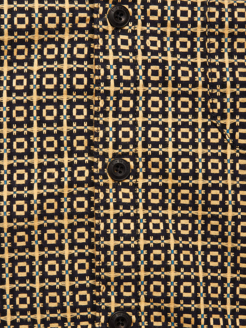 Close-up of the Manga Overshirt – Black Pattern by Blue de Gênes. Made from cotton, it features black buttons and a striking geometric design in yellow, blue, and black—an elevated men’s workwear piece.