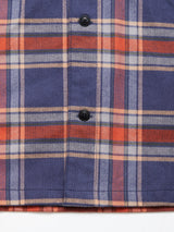 Close-up of the Blue de Gênes Yodo Check Overshirt - Multi Check in soft-touch moleskin, featuring blue, orange, white, and beige stripes with two black buttons and a cozy chevron texture for a relaxed fit.