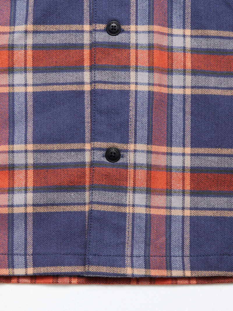 Close-up of the Blue de Gênes Yodo Check Overshirt - Multi Check in soft-touch moleskin, featuring blue, orange, white, and beige stripes with two black buttons and a cozy chevron texture for a relaxed fit.