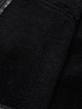 Close-up of the soft black shearling fabric and smooth leather trim from the Blue de Gênes Rufo Shearling Jacket - Scarab, highlighting its plush texture and detailed stitching.