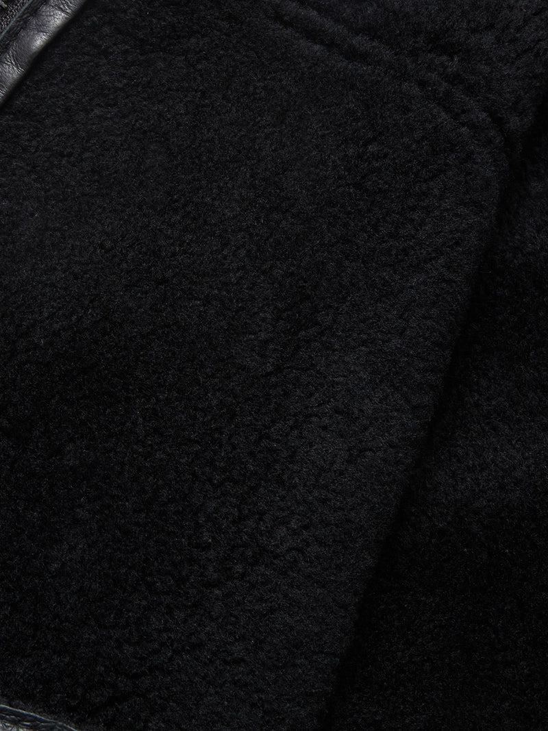 Close-up of the soft black shearling fabric and smooth leather trim from the Blue de Gênes Rufo Shearling Jacket - Scarab, highlighting its plush texture and detailed stitching.