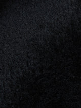 Close-up of the textured black surface of the Rufo Shearling Jacket - Scarab by Blue de Gênes, featuring soft, dense sheepskin with subtle shading and a wavy pattern—evoking the luxury of genuine shearling.