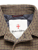Close-up of the collar and label of the Blue de Gênes Massone Check Coat - Multi Check. The label features a red and white shield logo. This winter coat shows a brown and navy check pattern with a quilted lining.