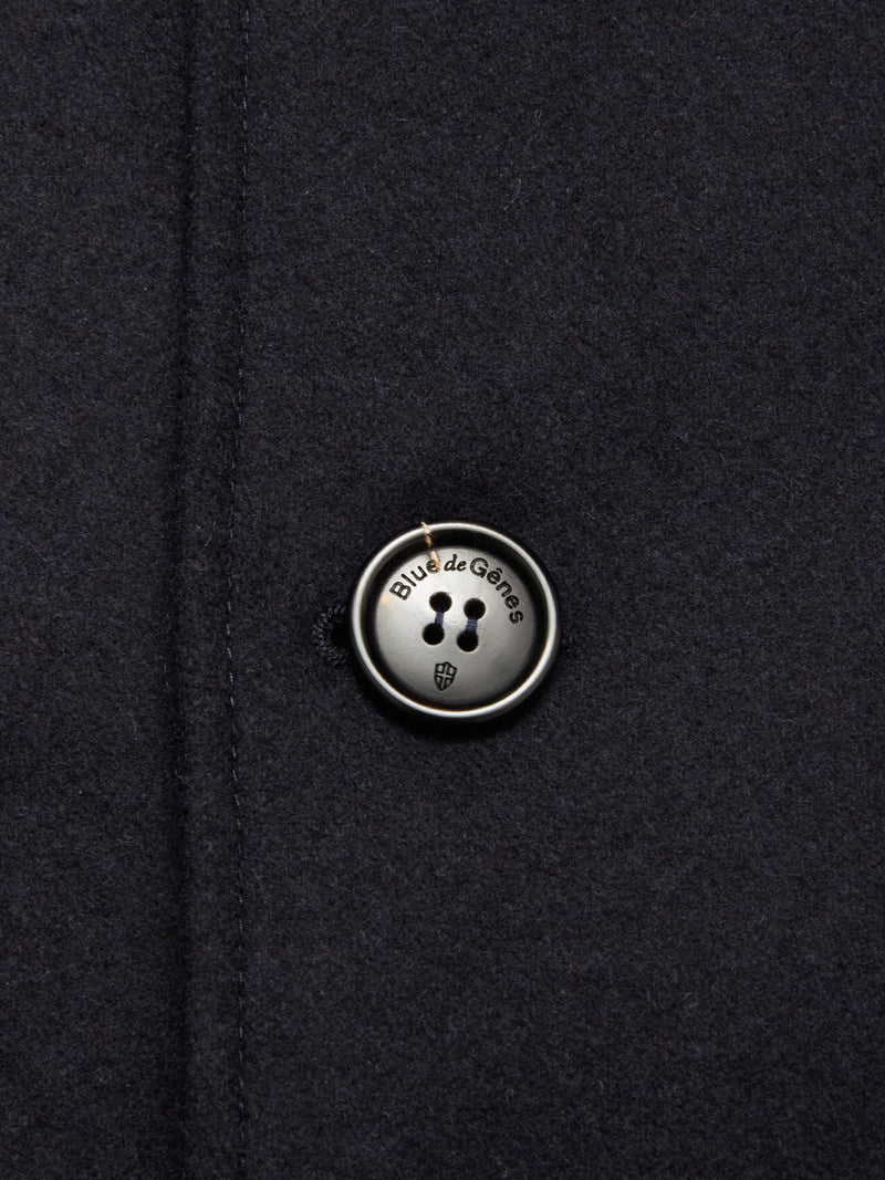 Close-up of the Shiba Melton Coat - Dark Navy by Blue de Gênes, showcasing a round, engraved four-hole button securely stitched on, adding refined detail to this classic Italian Melton wool peacoat.