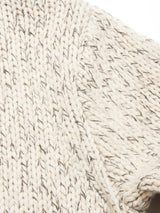 Close-up of the Sakura Knit Cardigan - Stone by Blue de Gênes, showing its cream-colored, thick knit with textured stitches and interwoven darker threads.
