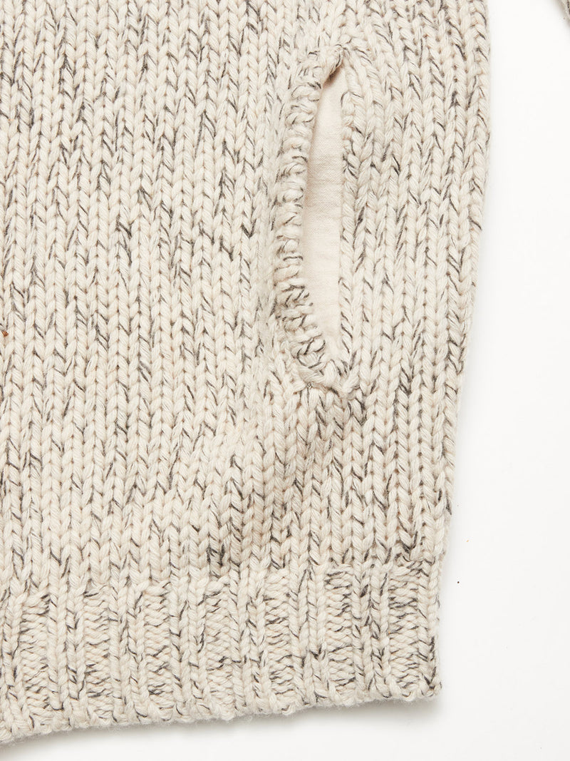 Close-up of the Sakura Knit Cardigan - Stone by Blue de Gênes, featuring chunky cream wool-blend yarn, a vertical side pocket, and ribbed hem for added texture.