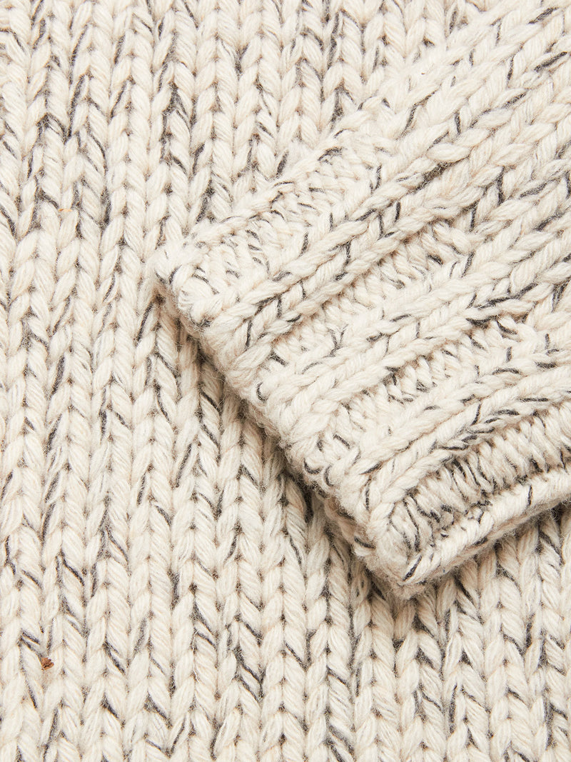Close-up of the Sakura Knit Cardigan - Stone by Blue de Gênes, a cream chunky wool blend with gray flecks and a folded sleeve—showcasing its cozy texture, perfect for layering.