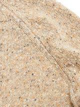 Close-up of the Honshu Crewneck Knit - Fungi by Blue de Gênes, featuring beige, speckled lambswool blend fabric with visible knit texture and seams, highlighted by flecks of brown, white, and gray throughout.