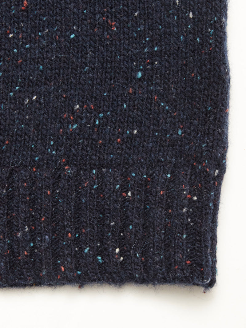 Close-up of the Honshu Crewneck Knit in Navy by Blue de Gênes, featuring chunky lambswool blend yarn with colorful red, white, and blue flecks and a ribbed edge that highlights its textured knit.