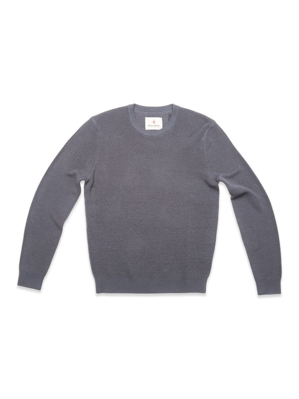 The Porto Knit - Dark Slate by Blue de Gênes is a classic men's crewneck sweater made from 100% wool, shown laid flat on a white background.
