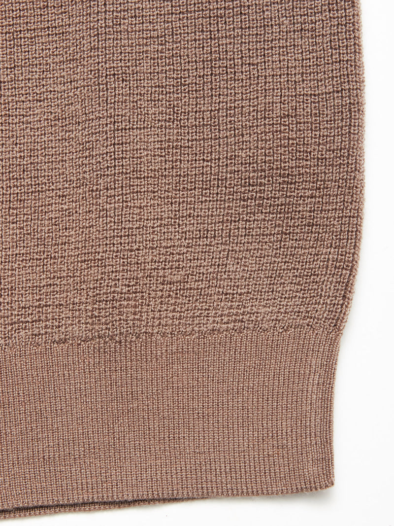 Close-up of the Porto Knit - Fungi by Blue de Gênes, showcasing its soft, finely woven 100% wool brown textured fabric and ribbed hem, ideal for menswear crewneck sweaters.