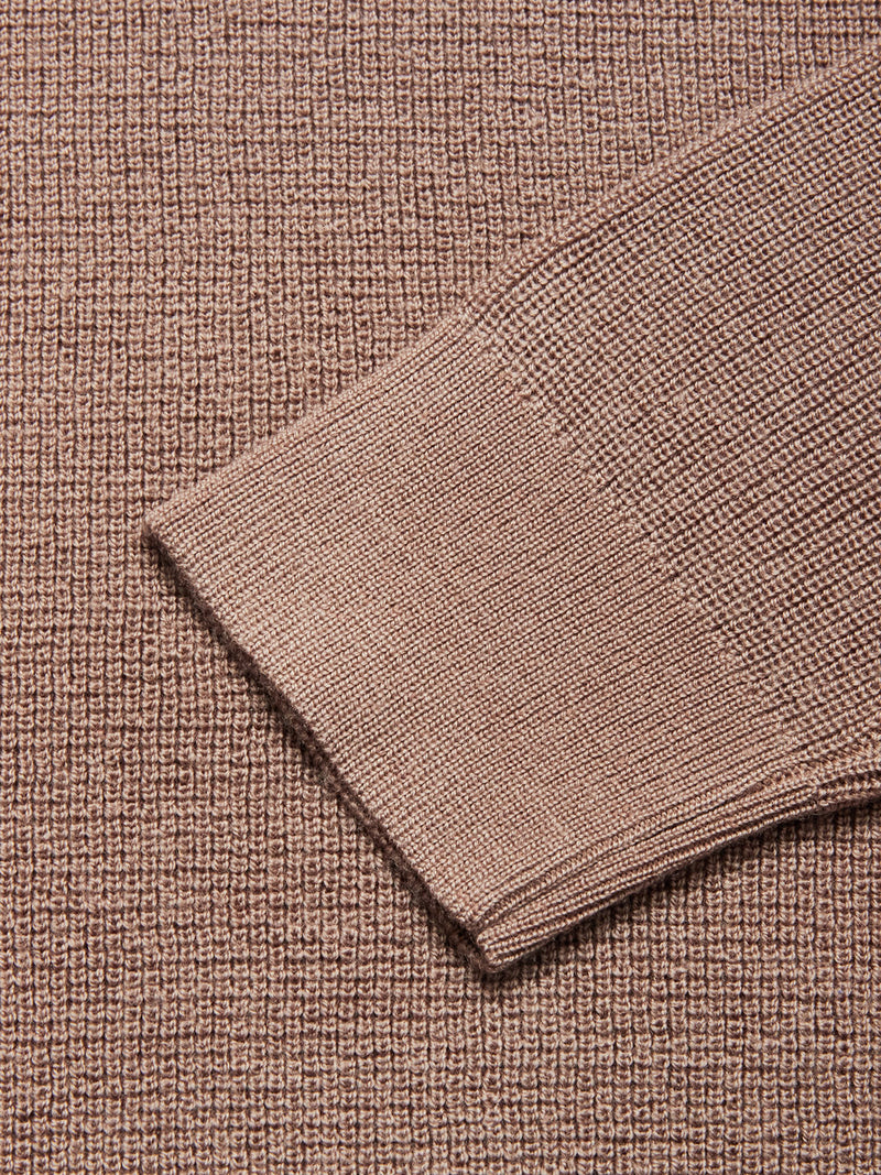 Close-up of the textured, light brown Porto Knit - Fungi sweater by Blue de Gênes, featuring a detailed view of its 100% wool knit and long sleeve folded over the main body.