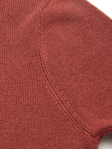 Close-up of the textured, henna-colored Porto Knit sweater by Blue de Gênes, highlighting the ribbed knit pattern and visible seam where the sleeve joins the body.