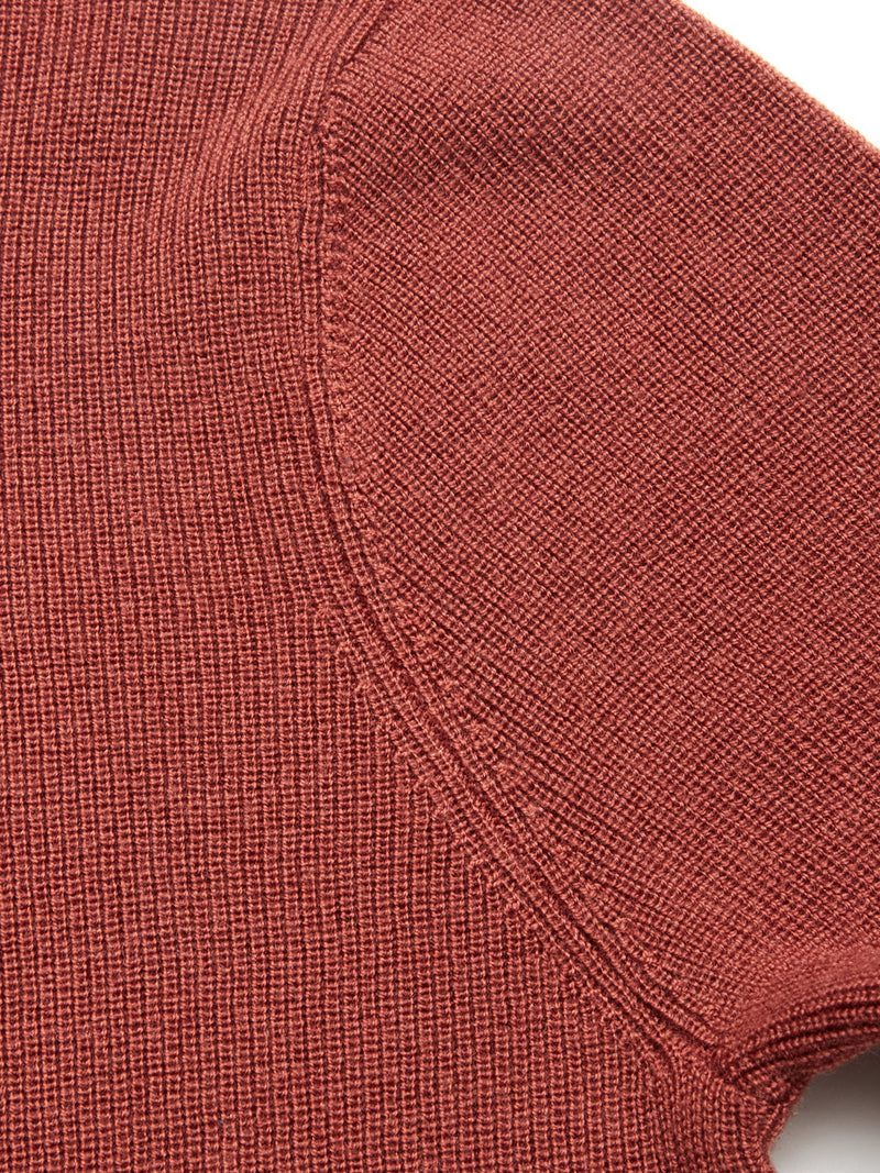 Close-up of the textured, henna-colored Porto Knit sweater by Blue de Gênes, highlighting the ribbed knit pattern and visible seam where the sleeve joins the body.