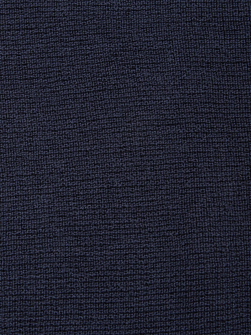 Close-up of the Porto Knit - Navy by Blue de Gênes: textured dark blue wool fabric with a subtle grid-like weave, giving this crewneck sweater a refined, tactile look—ideal for elegant menswear.