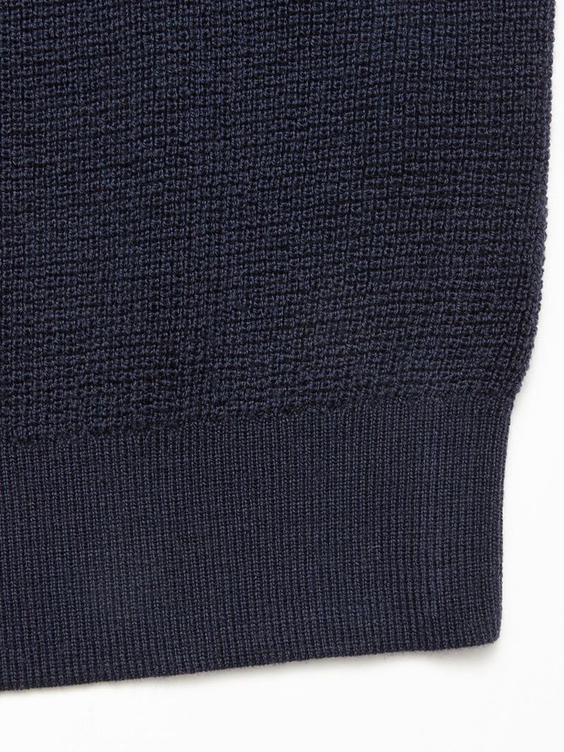 Close-up of the Porto Knit - Navy by Blue de Gênes, showcasing its textured wool fabric and ribbed hem against a white background.