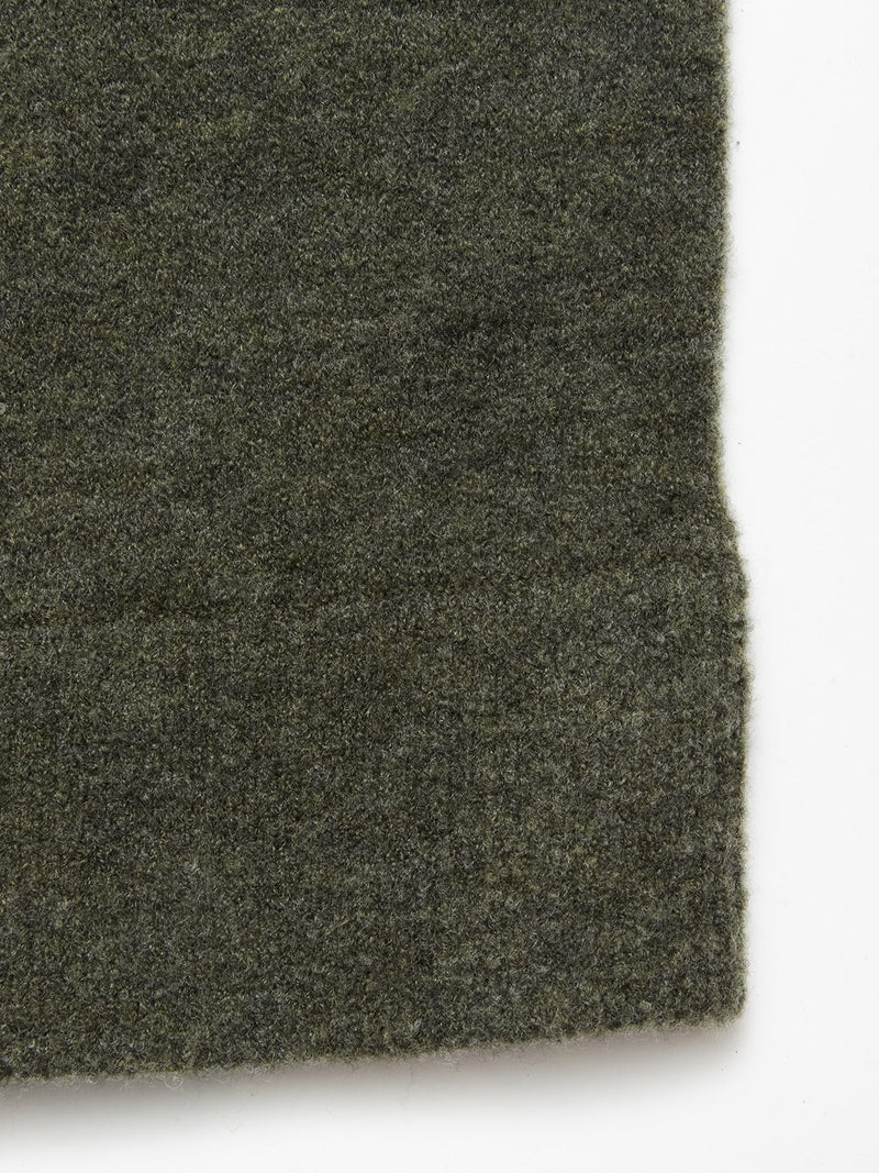 A close-up of Blue de Gênes Malakka Polo Knit - Army fabric, featuring its soft, fuzzy texture and slightly uneven edge, set against a white background.