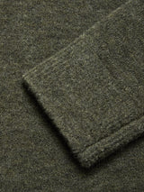 Close-up of a folded sleeve on the Blue de Gênes Malakka Polo Knit - Army, showcasing the soft, slightly fuzzy wool blend fabric in textured olive green.