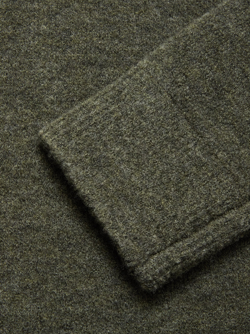 Close-up of a folded sleeve on the Blue de Gênes Malakka Polo Knit - Army, showcasing the soft, slightly fuzzy wool blend fabric in textured olive green.