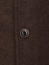 Close-up of the Blue de Gênes Kojima Wool Jacket - Chocolate, showing the textured brown boiled wool fabric and a single glossy, dark-centered button fastened through the buttonhole.