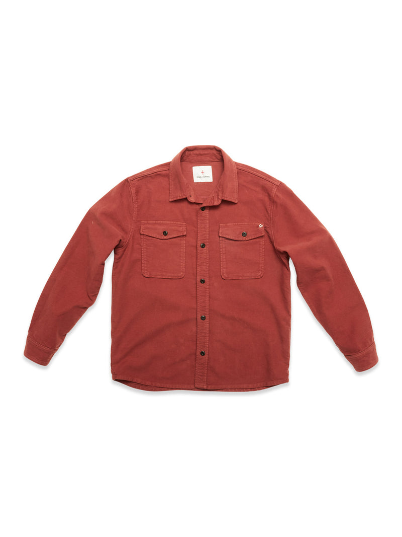 The Blue de Gênes Nagano Overshirt in Henna is a long-sleeve, button-up shirt made from soft Moleskin cotton, garment-dyed for rich color, with two chest pockets and shown flat on a white background.