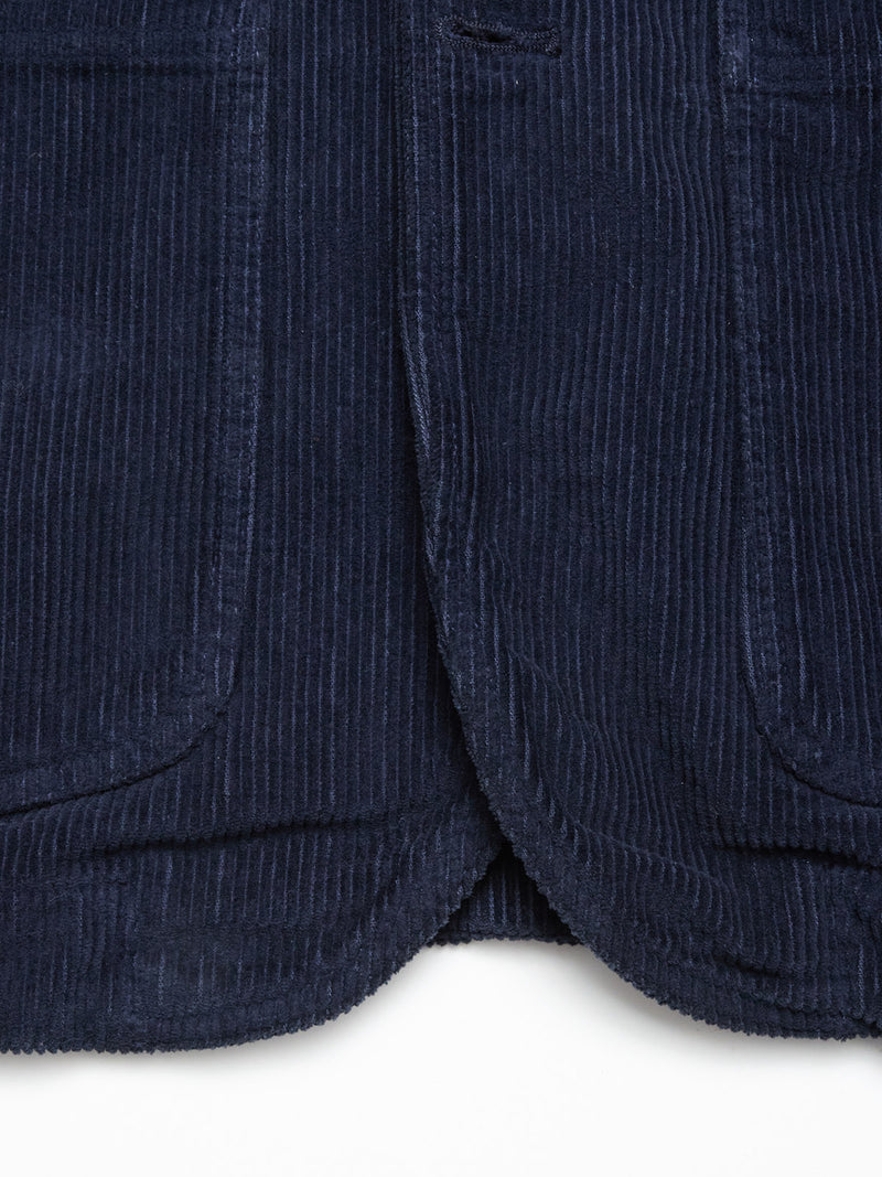 Close-up of the bottom hem of the Blue de Gênes Masami Cord Blazer - Navy, highlighting its garment-dyed corduroy with textured vertical ridges and two rounded-edge pockets on each side.