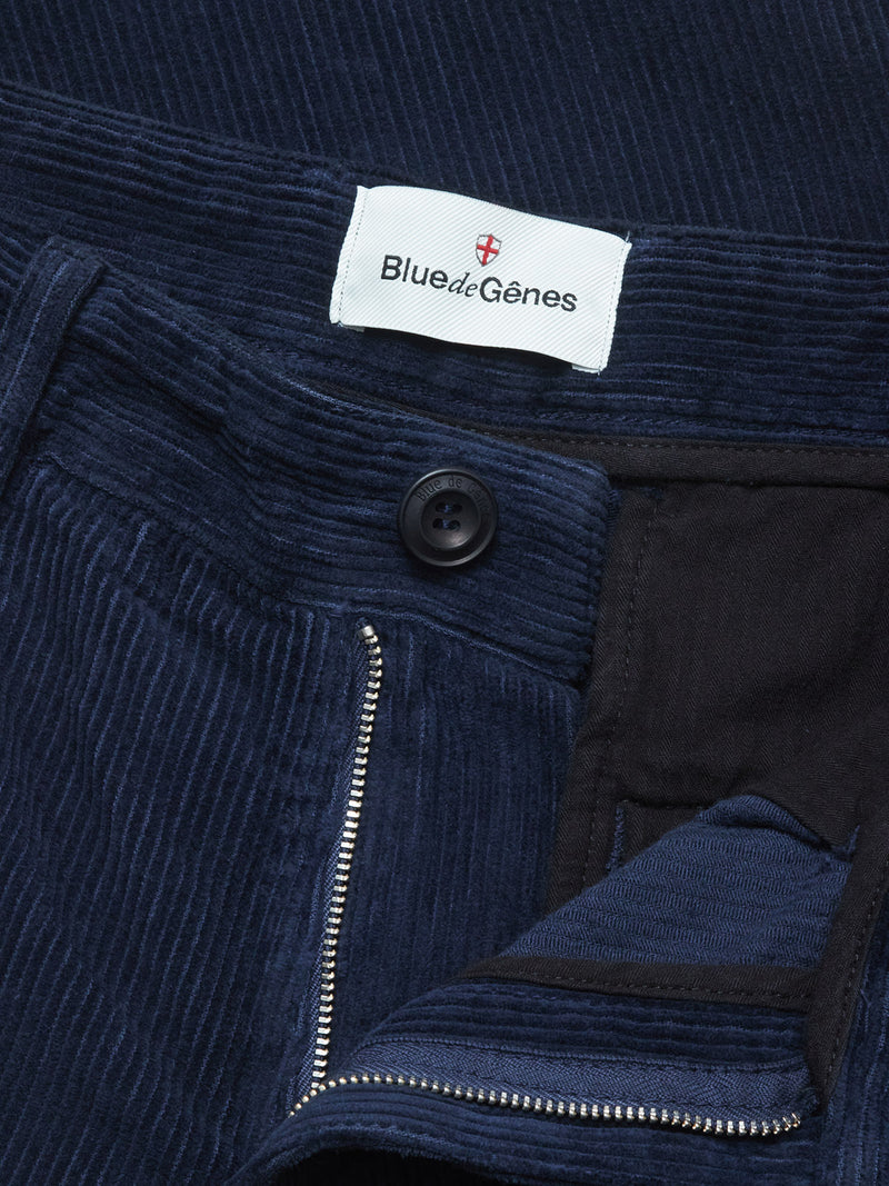 Close-up of Blue de Gênes Etsu Cord Chino - Navy in a relaxed fit, showcasing corduroy chino fabric, partially open zipper, black button, and a white brand label sewn inside the waistband.