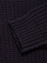 Close-up of the Yomaha Halfzip Knit in navy by Blue de Gênes, showing its ribbed texture, thick yarn, and folded cuff. The cozy wool blend highlights the chunky knit design.
