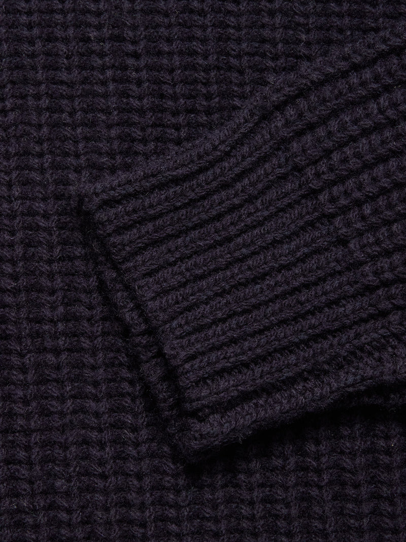 Close-up of the Yomaha Halfzip Knit in navy by Blue de Gênes, showing its ribbed texture, thick yarn, and folded cuff. The cozy wool blend highlights the chunky knit design.