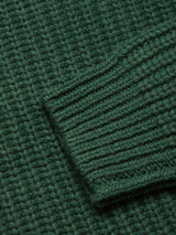 Close-up of the Yomaha Halfzip Knit - Scarab by Blue de Gênes, featuring a textured ribbed pattern in chunky green knit with a diagonal sleeve cuff detail.