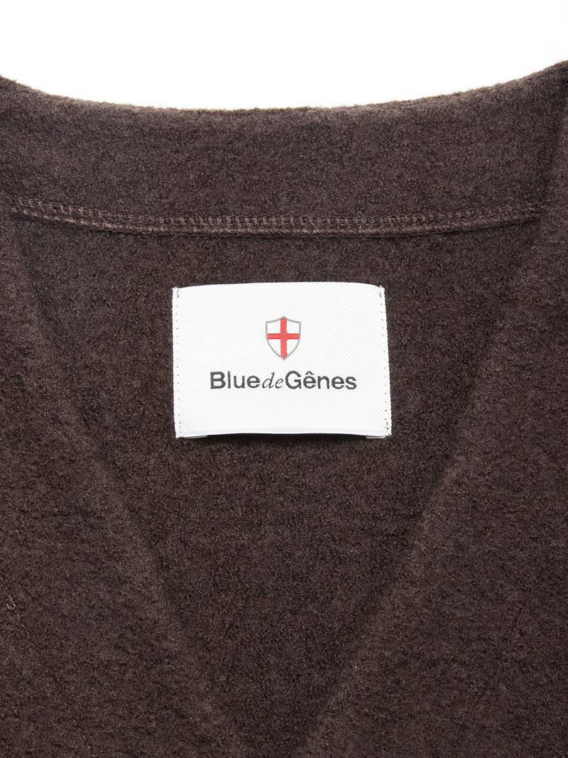 Close-up of the Koi Wool Gilet in Chocolate by Blue de Gênes, featuring a white label and red-and-white shield logo sewn inside the collar.