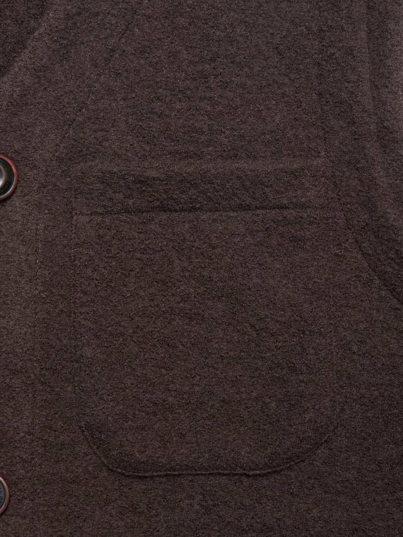 Close-up of the Blue de Gênes Koi Wool Gilet in Chocolate, highlighting its brown textured fabric, patch pocket, and two dark buttons on the left edge.