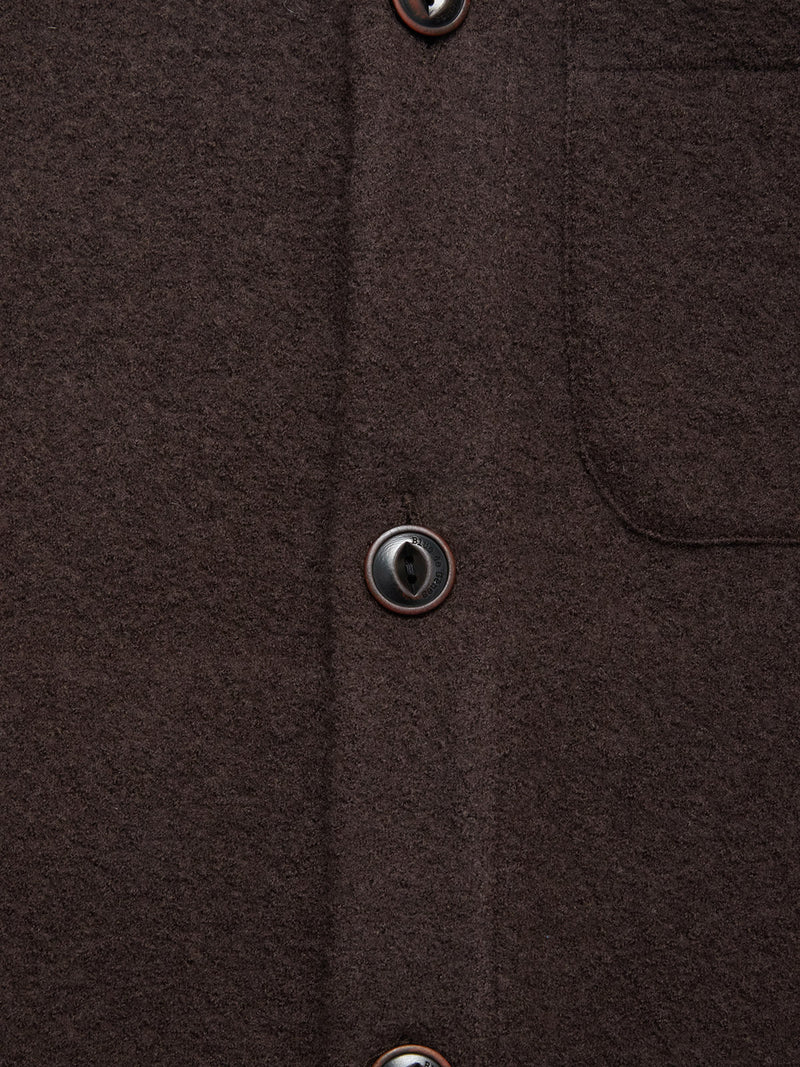 Close-up of a brown wool shirt with black buttons and chest pocket detail—pairs perfectly with the Blue de Gênes Koi Wool Gilet in Chocolate for added style.